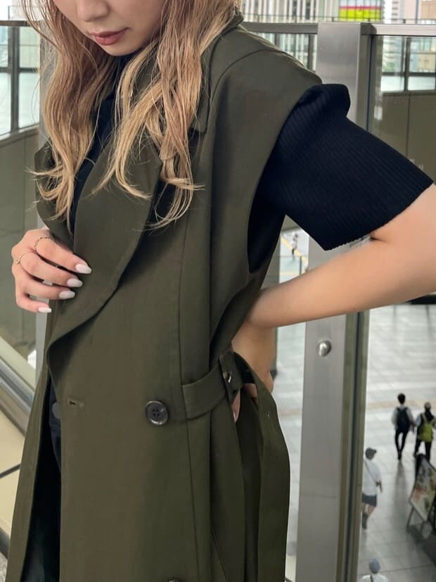 ブラック系のデニムパンツ、ブラック系のニット/セーター、ベージュ系のトレンチコートを着用したレディースの夏コーディネートの6枚目の写真