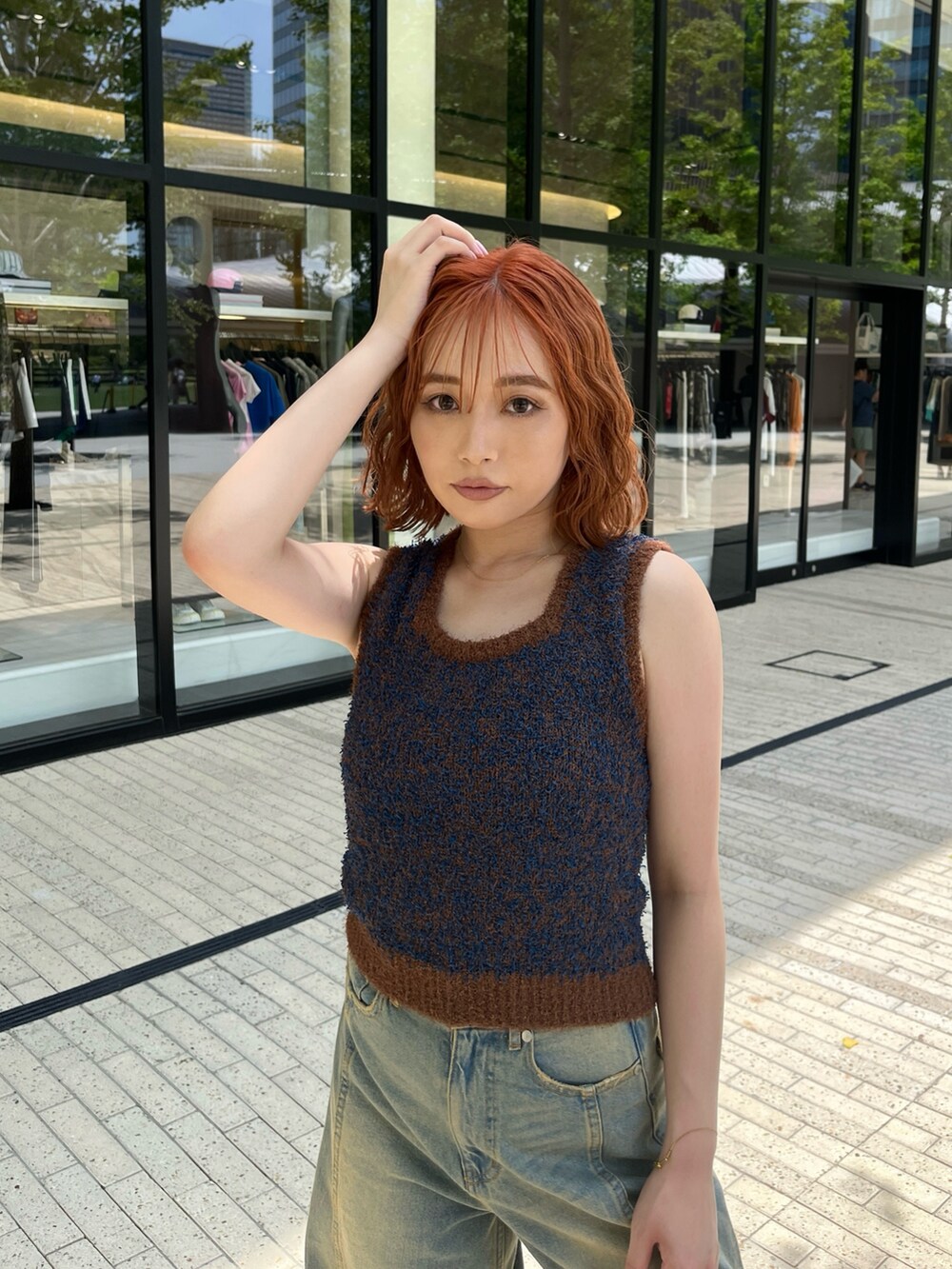 ブラウン系のニット/セーター、ブルー系のデニムパンツ、ブラック系のサンダルを着用したレディースの夏コーディネートの2枚目の写真