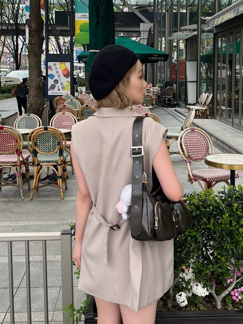 ブラック系のタンクトップ、ベージュ系のベスト、ブラウン系のハンドバッグを着用したレディースの春コーディネートの5枚目の写真