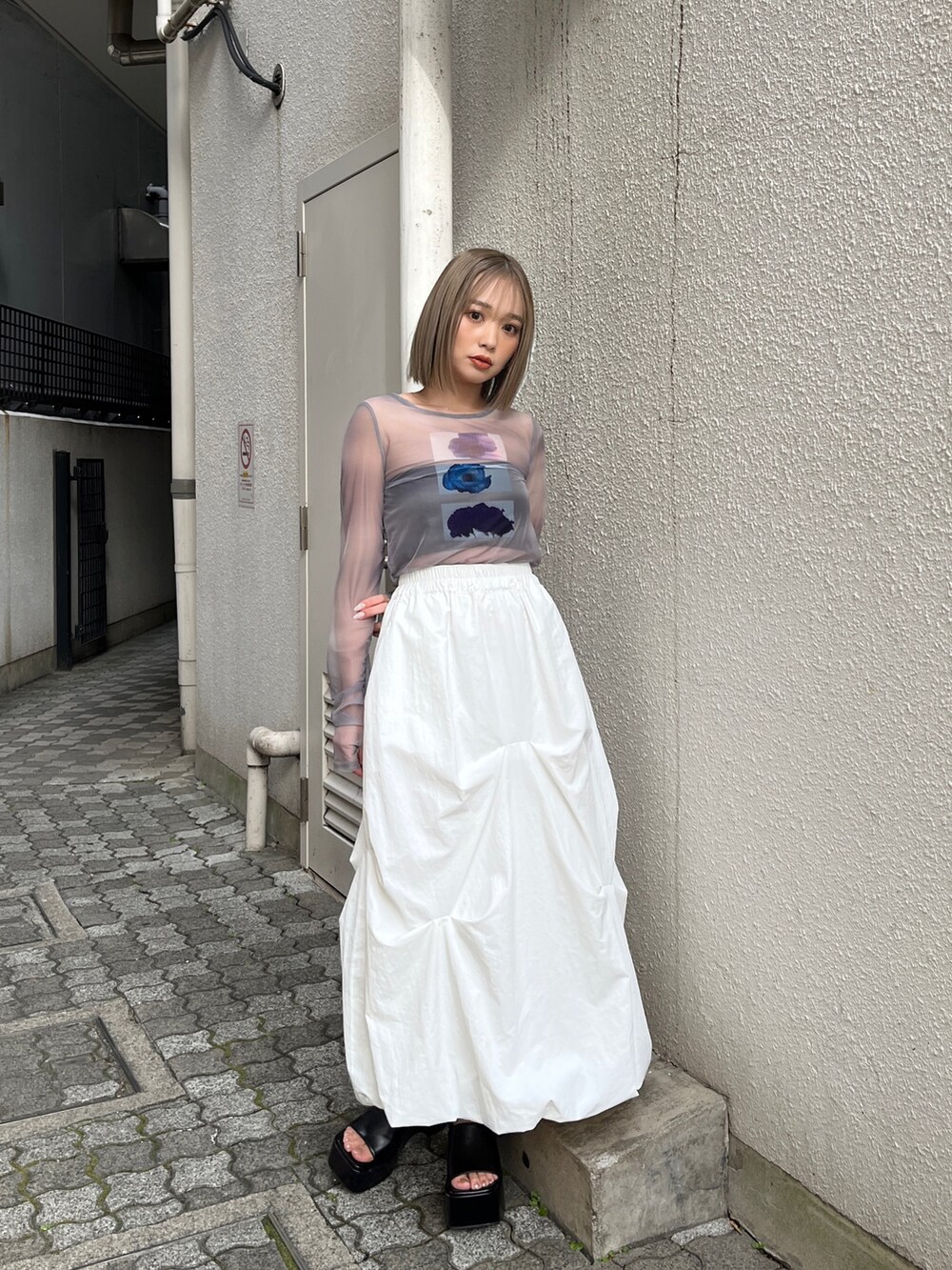 グレー系のTシャツ/カットソー、ホワイト系のベスト、ホワイト系のスカートを着用したレディースの冬コーディネートの8枚目の写真