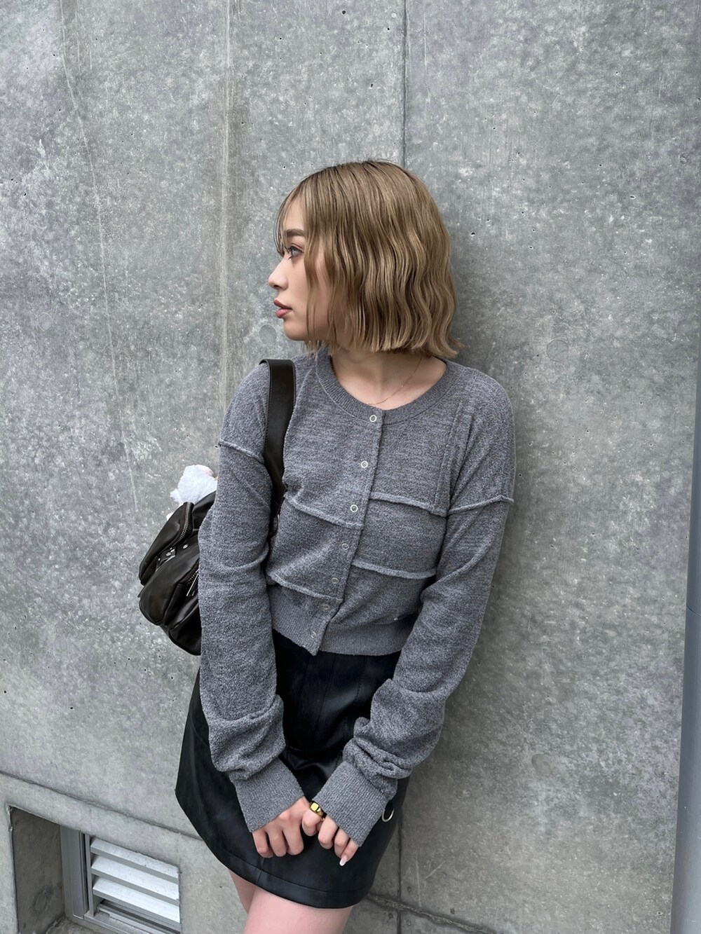 ブラック系のブーツ、ブラック系のスカート、グレー系のカーディガン/ボレロを着用したレディースの春コーディネートの4枚目の写真