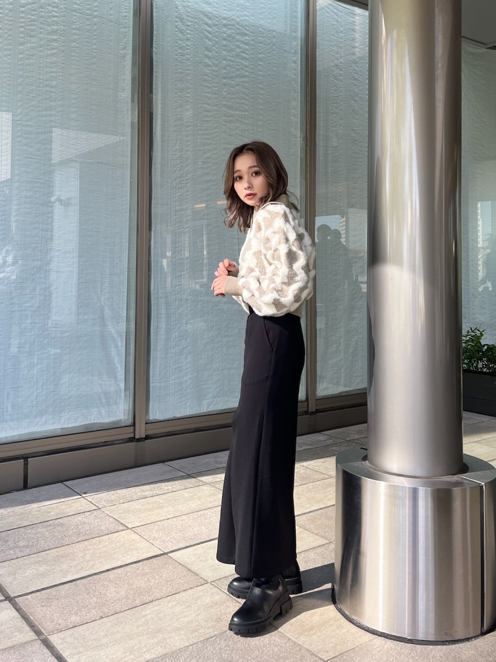 ベージュ系のニット/セーター、ブラック系のスカート、ブラック系のブーツを着用したレディースの秋コーディネートの3枚目の写真