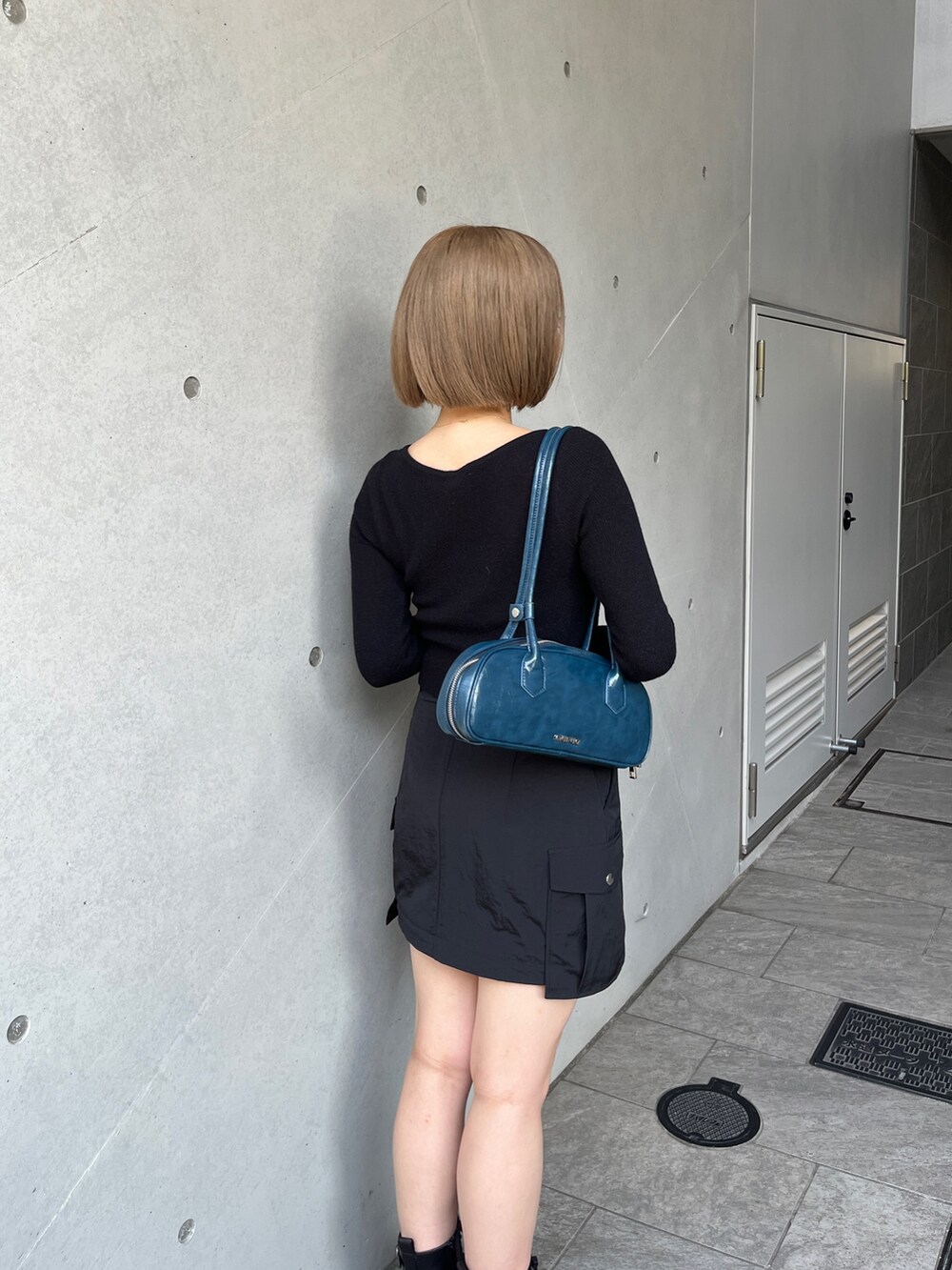 ブラック系のブーツ、ブラック系のスカート、ブラック系のニット/セーターを着用したレディースの夏コーディネートの5枚目の写真