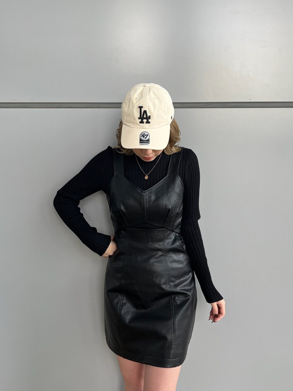 ブラック系のワンピース、ブラック系のニット/セーター、グレー系のスニーカーを着用したレディースの冬コーディネートの4枚目の写真