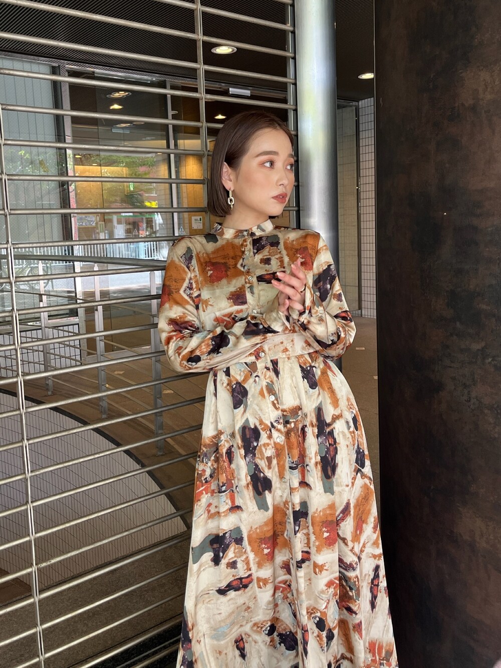 ブラウン系のブーツ、オレンジ系のワンピースを着用したレディースの秋コーディネートの4枚目の写真