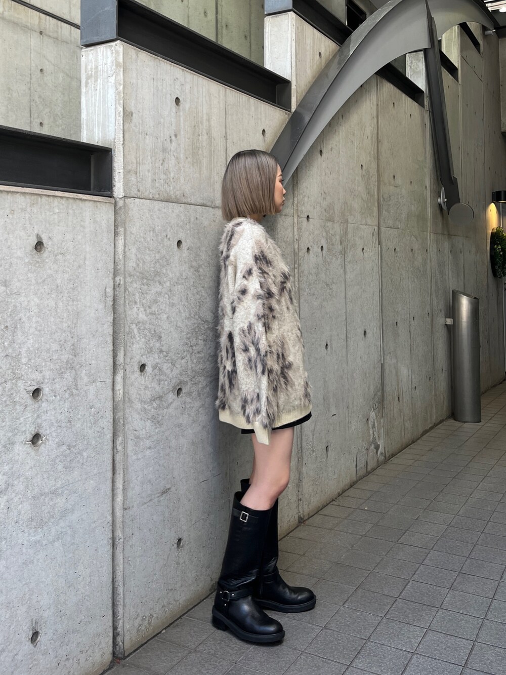 ホワイト系のニット/セーター、ブラック系のブーツを着用したレディースの秋コーディネートの4枚目の写真