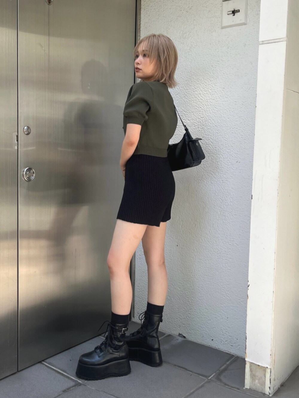 グリーン系のニット/セーター、ブラック系のその他パンツ、ブラック系のブーツを着用したレディースの秋コーディネートの3枚目の写真