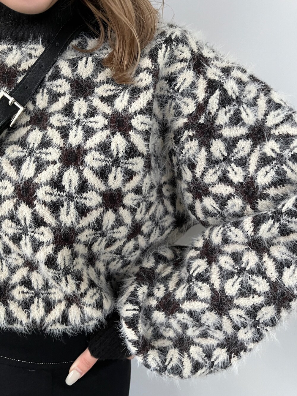 ブラック系のニット/セーター、ブラック系のスカート、ブラック系のショルダーバッグを着用したレディースの秋コーディネートの6枚目の写真