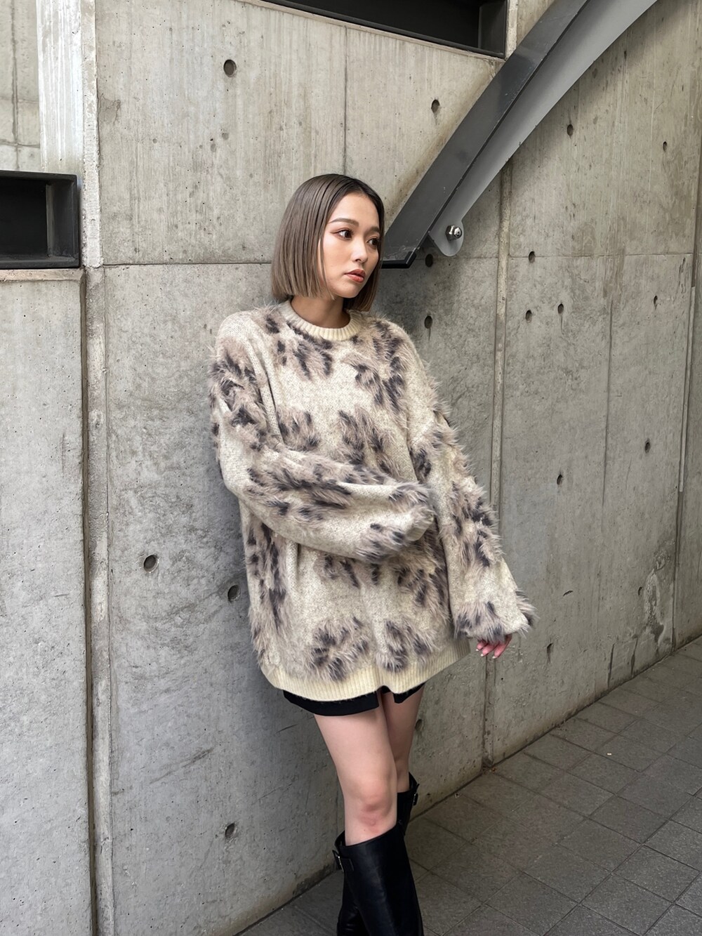 ホワイト系のニット/セーター、ブラック系のブーツを着用したレディースの秋コーディネートの6枚目の写真