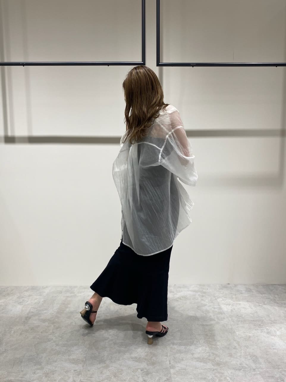 ブラック系のスカート、ホワイト系のシャツ/ブラウス、ブラック系のサンダルを着用したレディースの春コーディネートの4枚目の写真