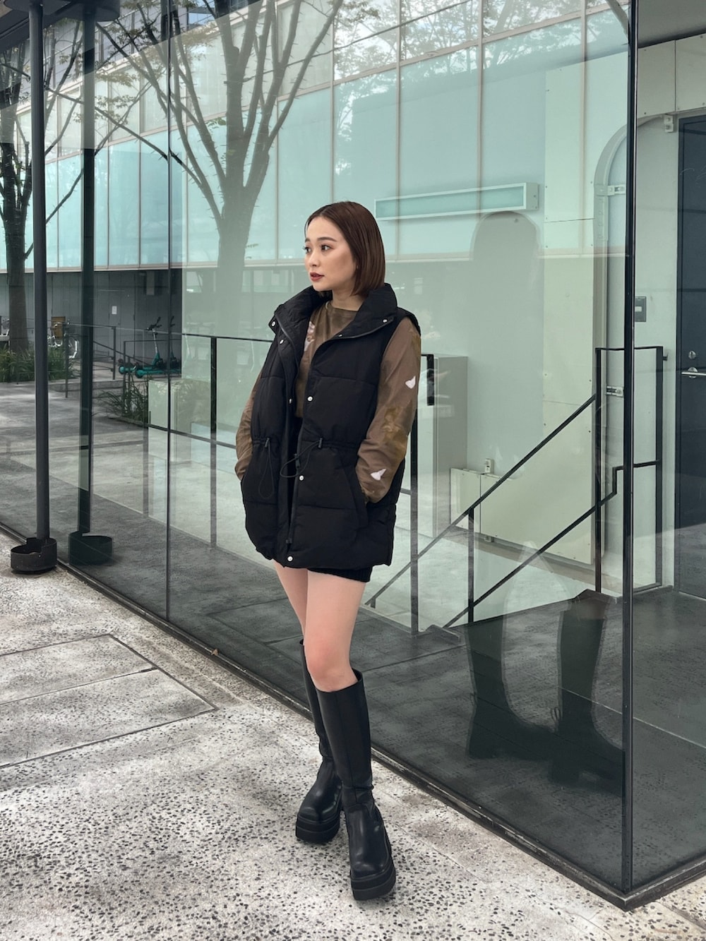 ブラック系のダウンベスト、ブラウン系のTシャツ/カットソー、ブラック系のその他パンツを着用したレディースの秋コーディネートの2枚目の写真