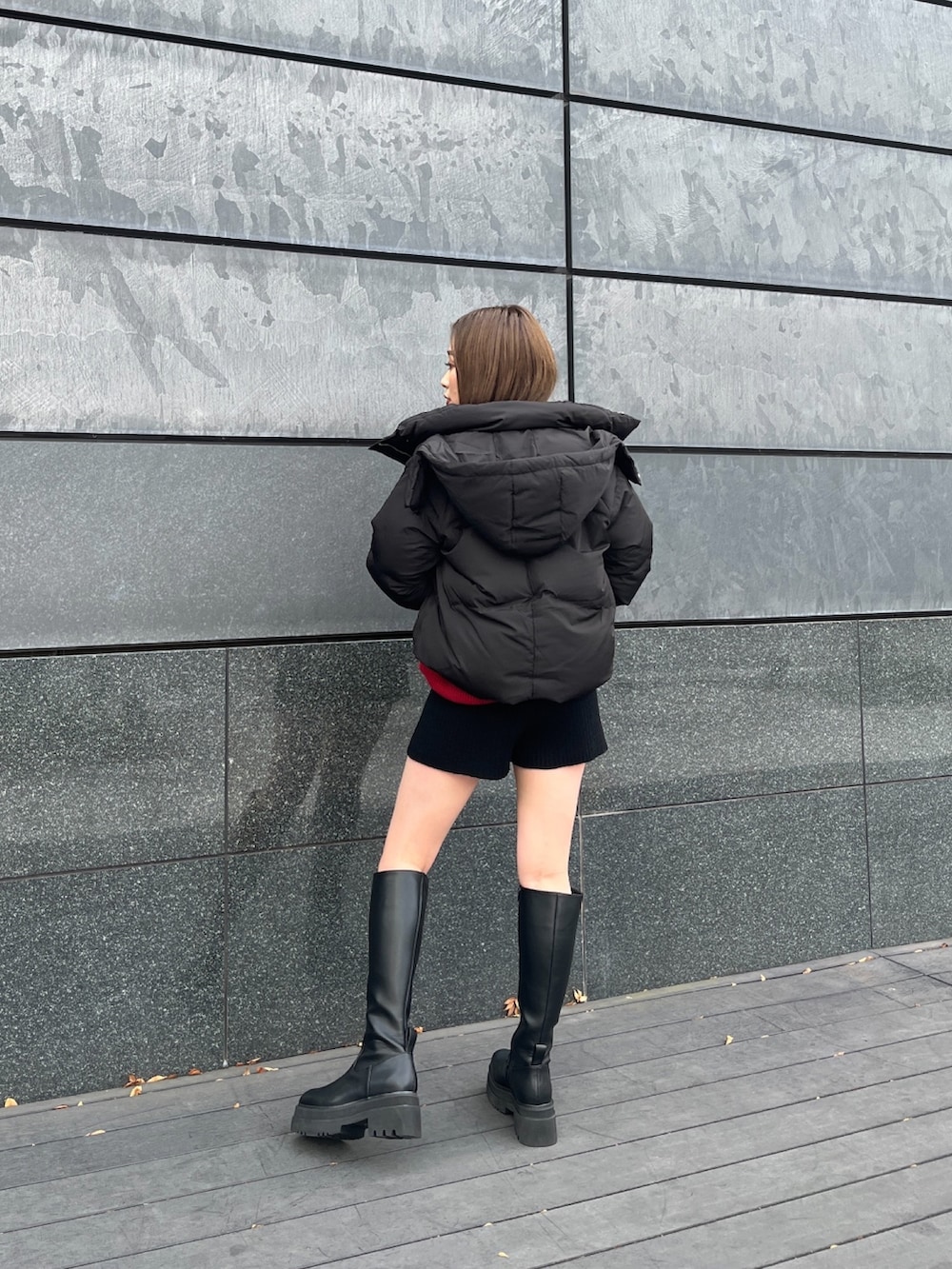 ブラック系のダウンジャケット/コート、レッド系のニット/セーター、ブラック系のその他パンツを着用したレディースの冬コーディネートの2枚目の写真
