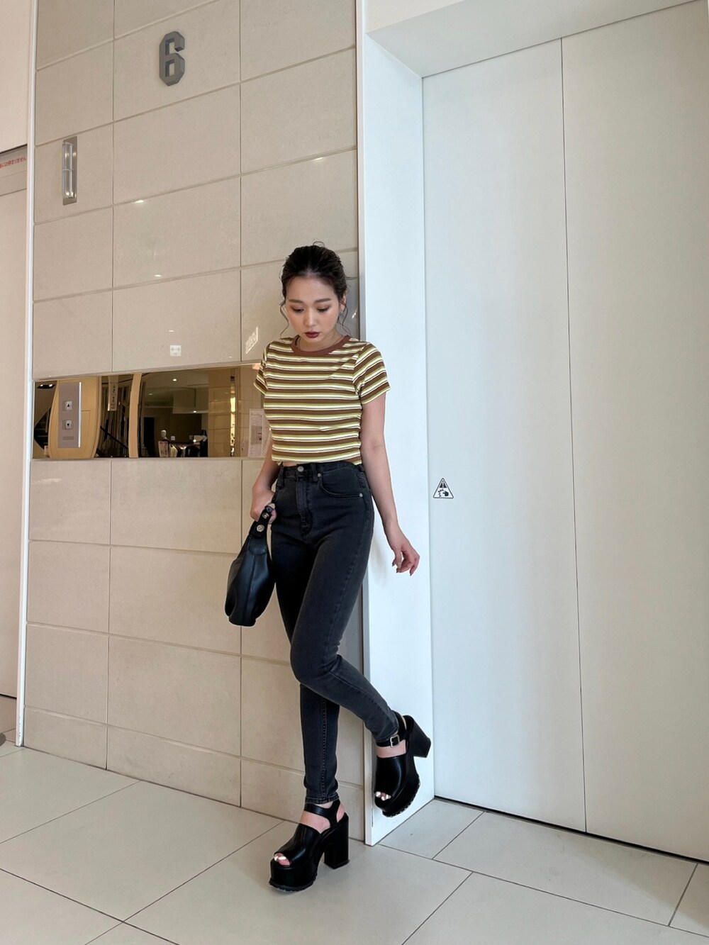 イエロー系のTシャツ/カットソー、グレー系のデニムパンツ、ブラック系のサンダルを着用したレディースの春コーディネートの2枚目の写真