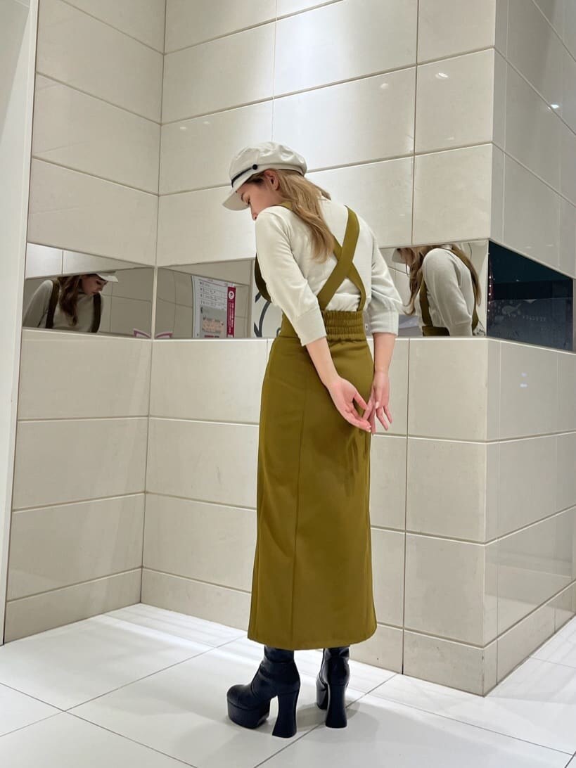 イエロー系のワンピース、ブラック系のブーツ、ホワイト系のニット/セーターを着用したレディースの秋コーディネートの3枚目の写真