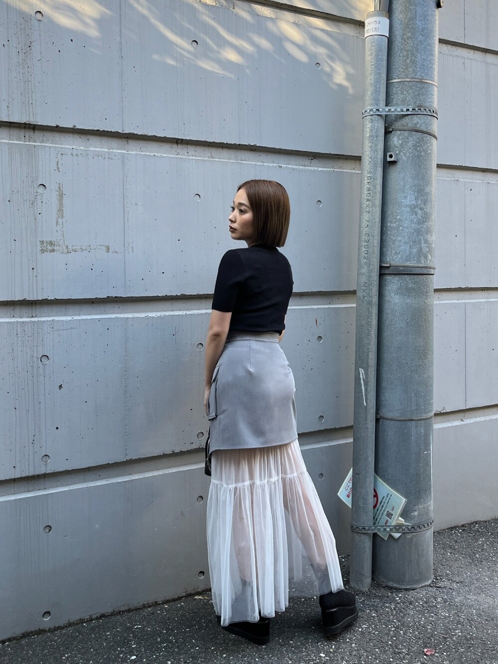 ブラック系のニット/セーター、ブラック系のブーツを着用したレディースの冬コーディネートの2枚目の写真