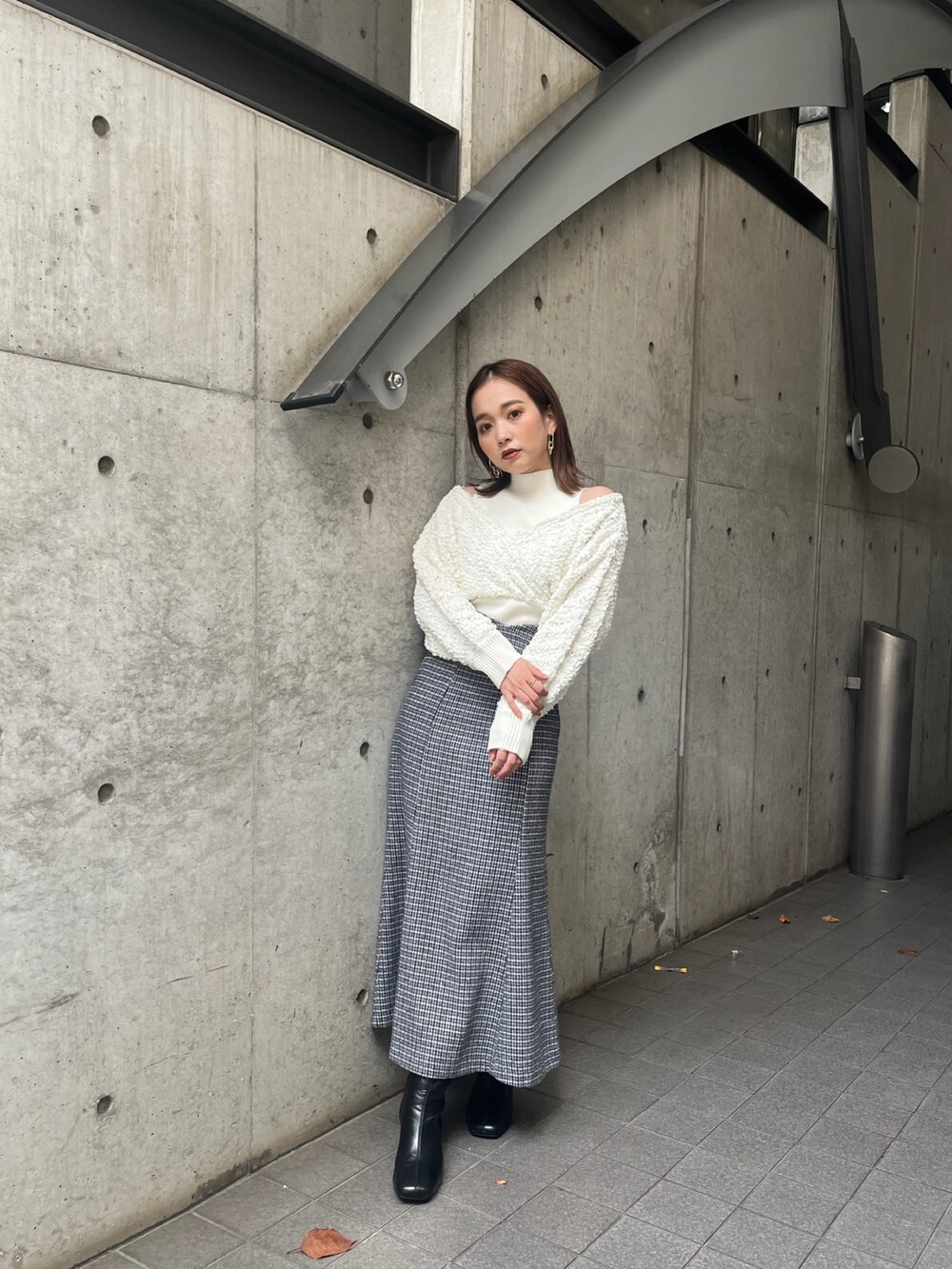 ホワイト系のニット/セーター、その他のスカート、ブラック系のブーツを着用したレディースの秋コーディネートの2枚目の写真