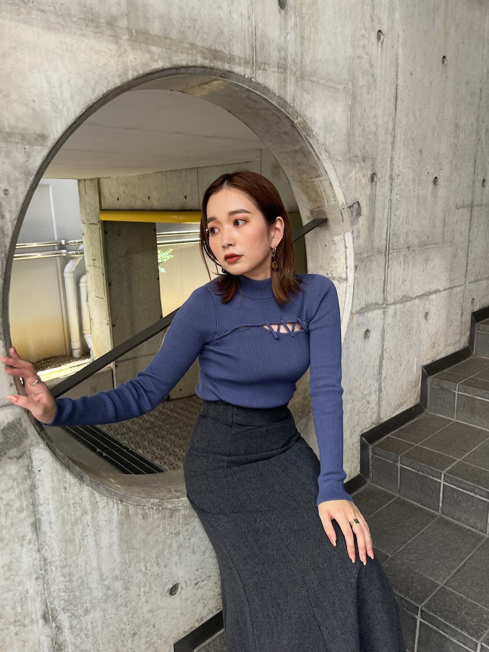 ブルー系のニット/セーター、ブラック系のスカート、ホワイト系のブーツを着用したレディースの秋コーディネートの3枚目の写真