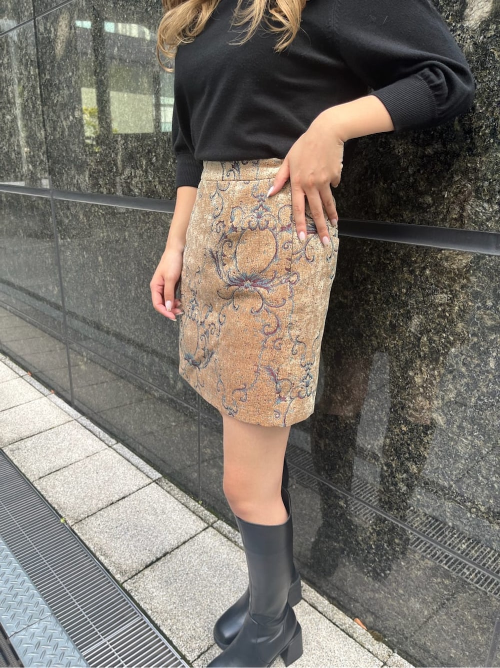 ブラック系のブーツ、ブラック系のニット/セーター、ブラウン系のスカートを着用したレディースの秋コーディネートの8枚目の写真