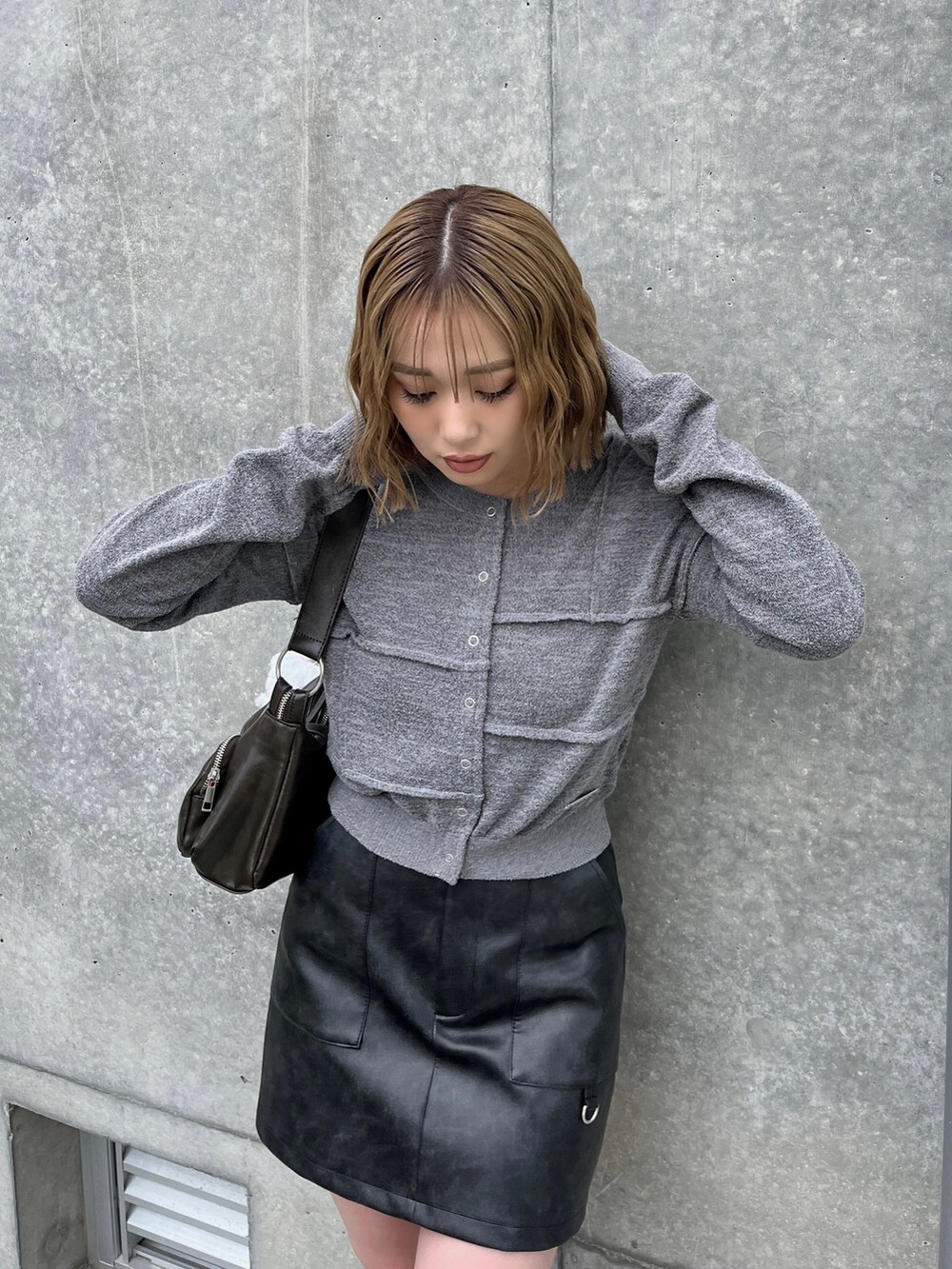 ブラック系のブーツ、ブラック系のスカート、グレー系のカーディガン/ボレロを着用したレディースの春コーディネートの5枚目の写真