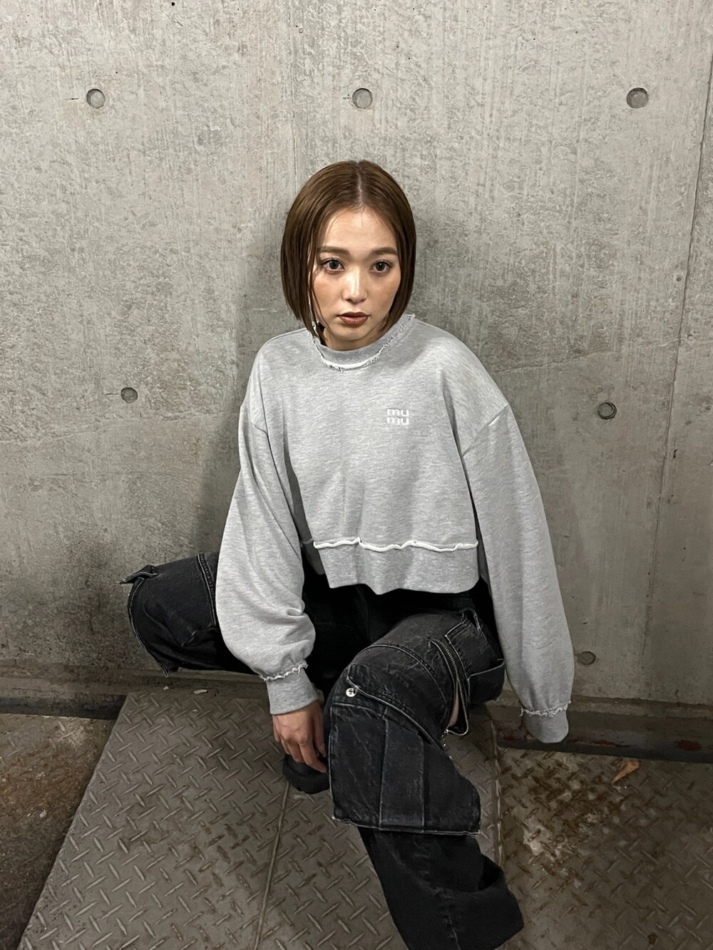 グレー系のスウェット、ブラック系のデニムパンツを着用したレディースの秋コーディネートの3枚目の写真