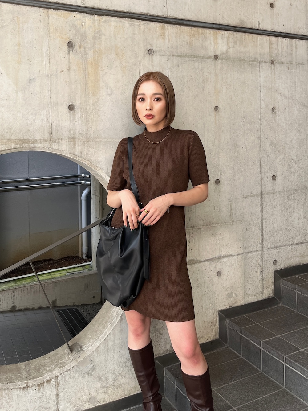 ブラウン系のワンピース、ブラウン系のブーツ、ブラック系のハンドバッグを着用したレディースの夏コーディネートの4枚目の写真