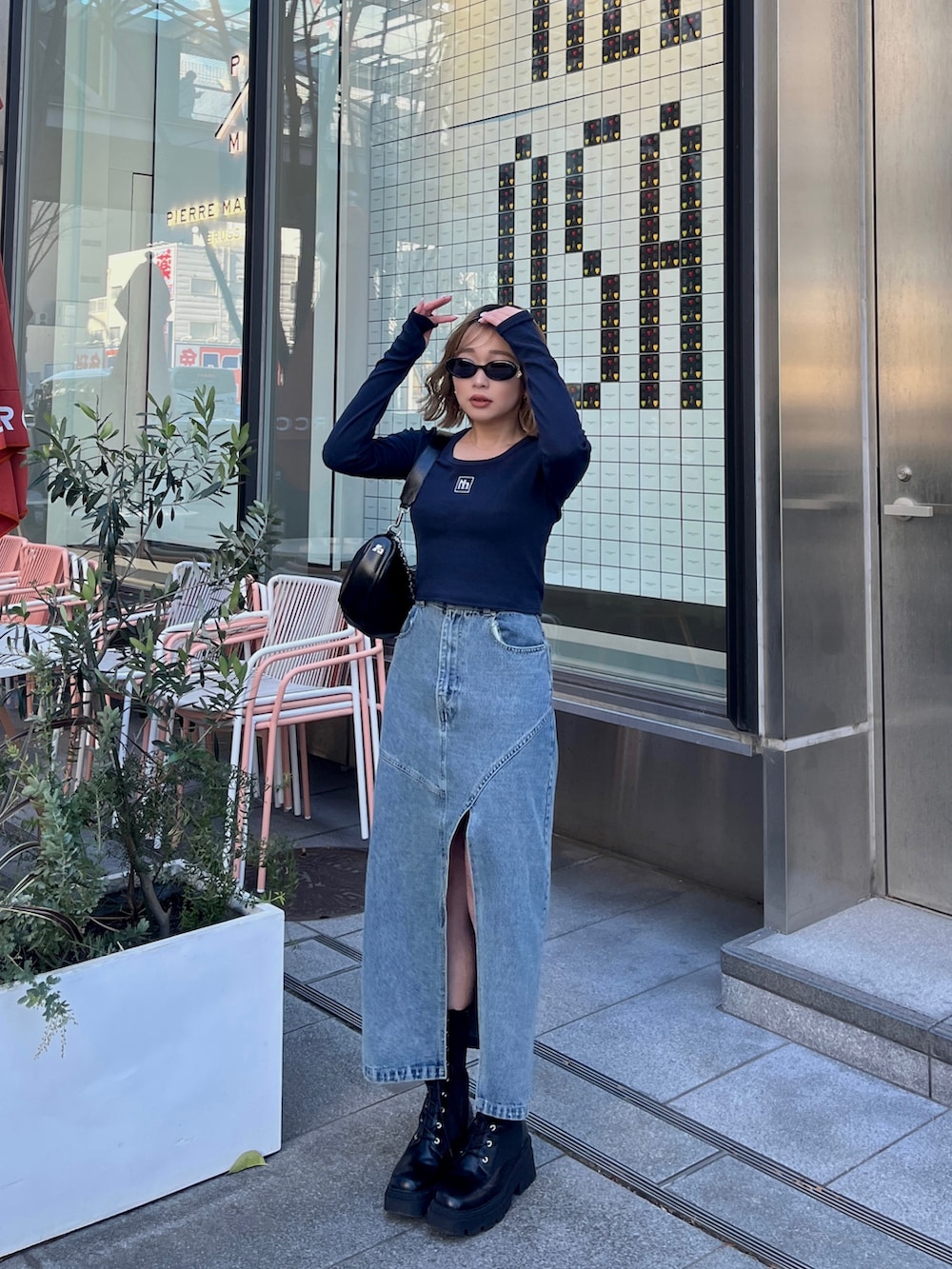 ブルー系のTシャツ/カットソー、ブルー系のデニムスカート、ブラック系のショルダーバッグを着用したレディースの春コーディネートの2枚目の写真