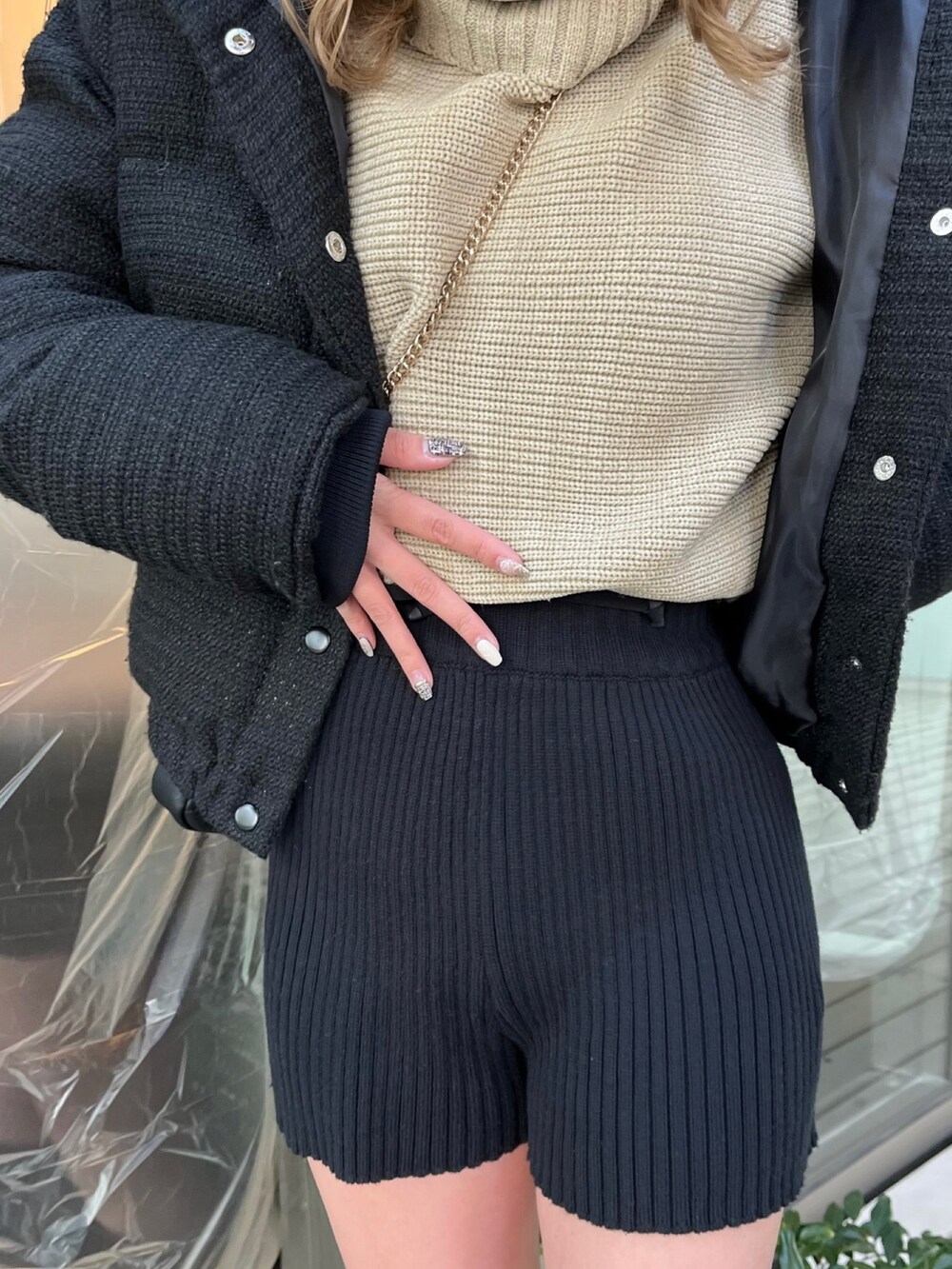 ブラック系のダウンジャケット/コート、ブラック系のスウェットパンツ、ベージュ系のニット/セーターを着用したレディースの冬コーディネートの9枚目の写真