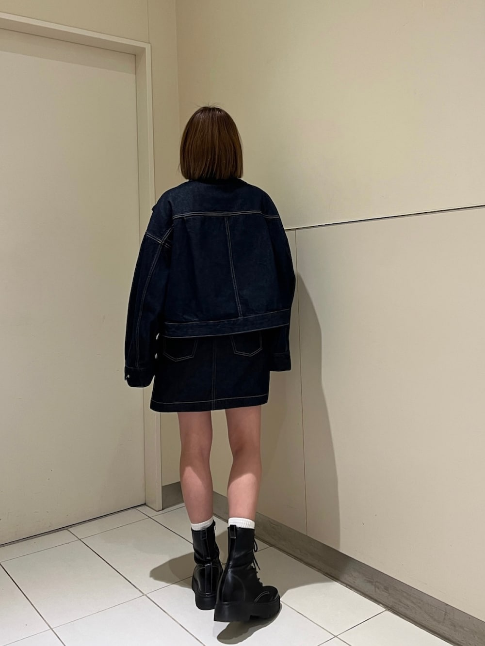 グリーン系のニット/セーター、ブルー系のデニムジャケット、ブルー系のワンピースを着用したレディースの冬コーディネートの2枚目の写真