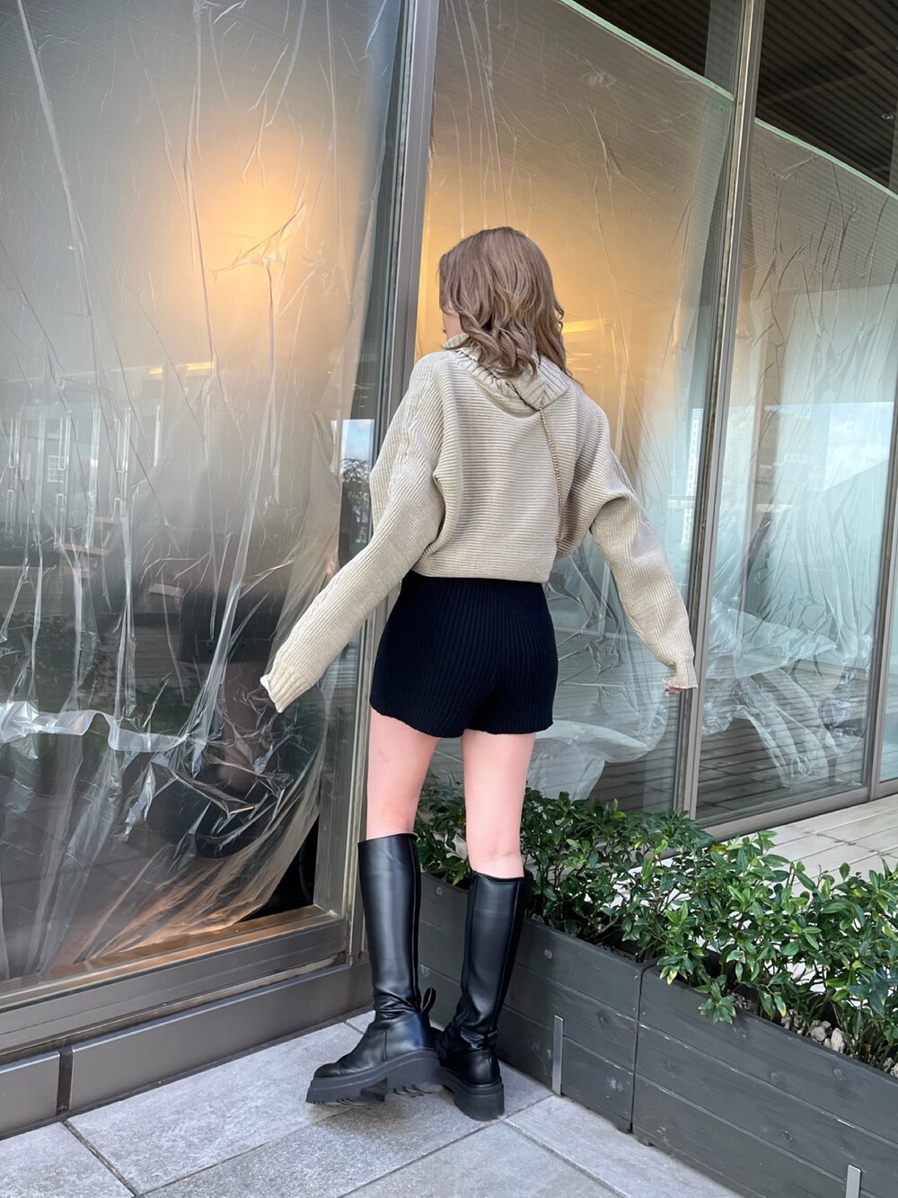 ブラック系のダウンジャケット/コート、ブラック系のスウェットパンツ、ベージュ系のニット/セーターを着用したレディースの冬コーディネートの5枚目の写真