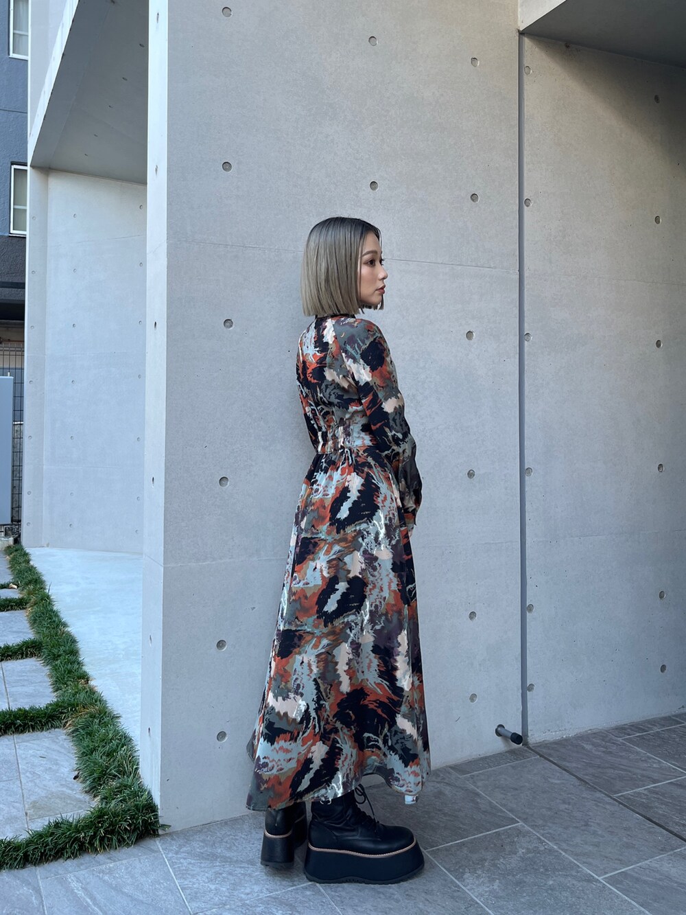 グレー系のブルゾン、ブラウン系のワンピース、ブラック系のブーツを着用したレディースの秋コーディネートの7枚目の写真