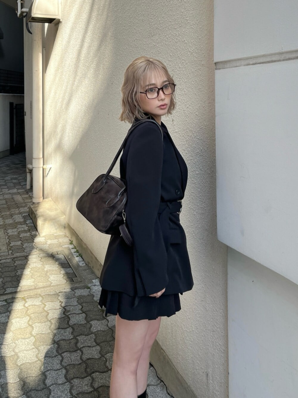 ブラック系のブーツ、ブラック系のテーラードジャケット、ブラウン系のキャミソールを着用したレディースの春コーディネートの8枚目の写真