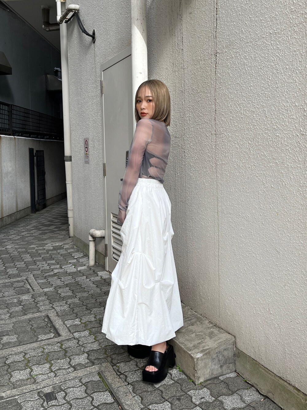 グレー系のTシャツ/カットソー、ホワイト系のベスト、ホワイト系のスカートを着用したレディースの冬コーディネートの9枚目の写真