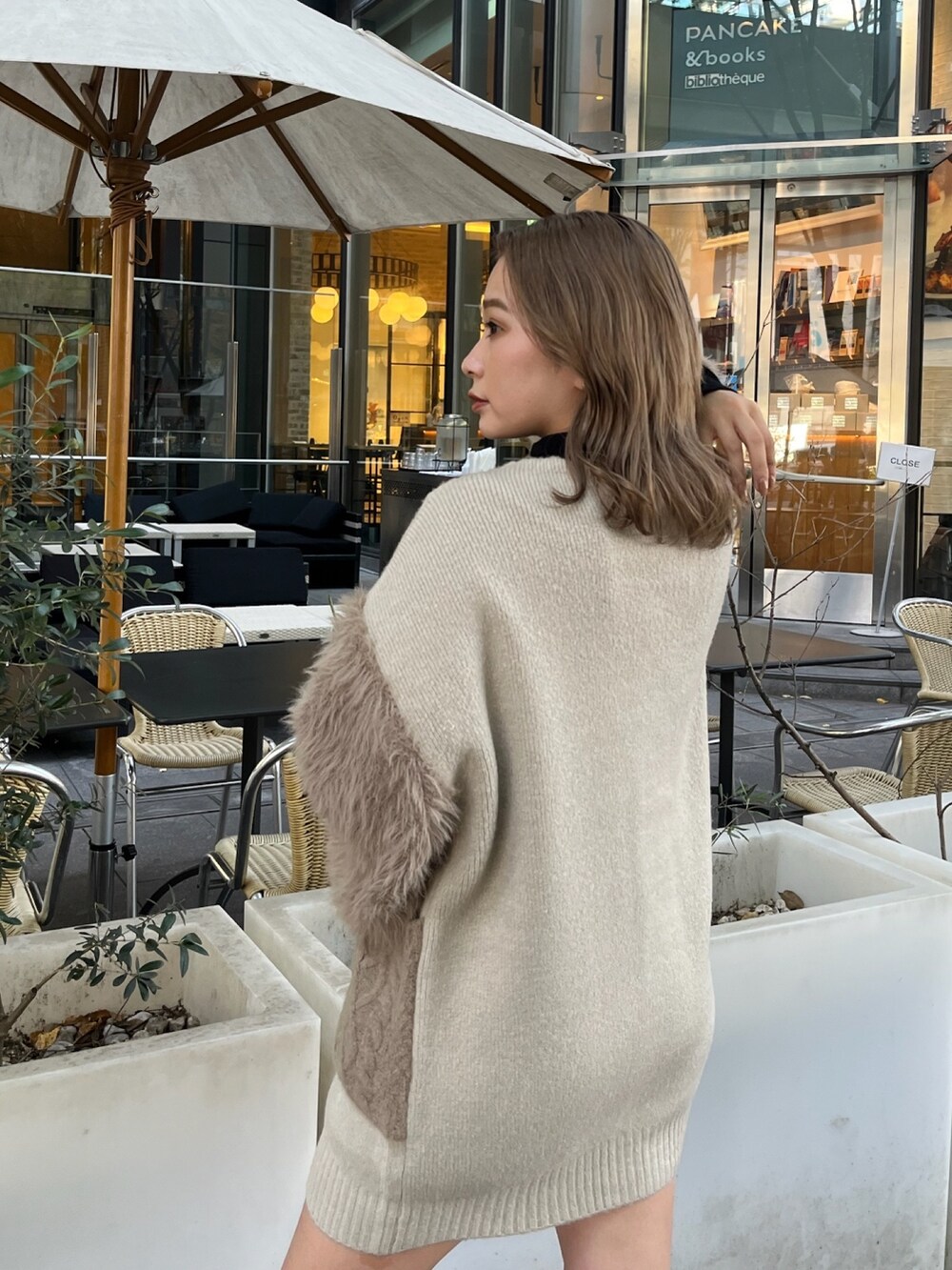 ベージュ系のカーディガン/ボレロ、ブラック系のニット/セーター、ブラック系のブーツを着用したレディースの秋コーディネートの7枚目の写真