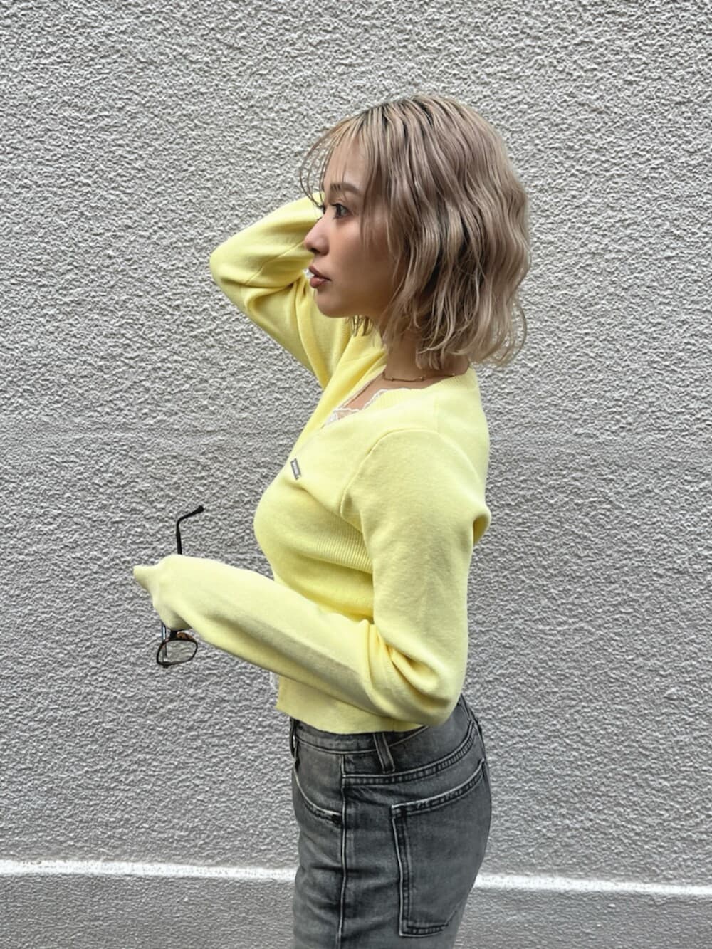 ブラック系のブーツ、イエロー系のニット/セーターを着用したレディースの春コーディネートの6枚目の写真