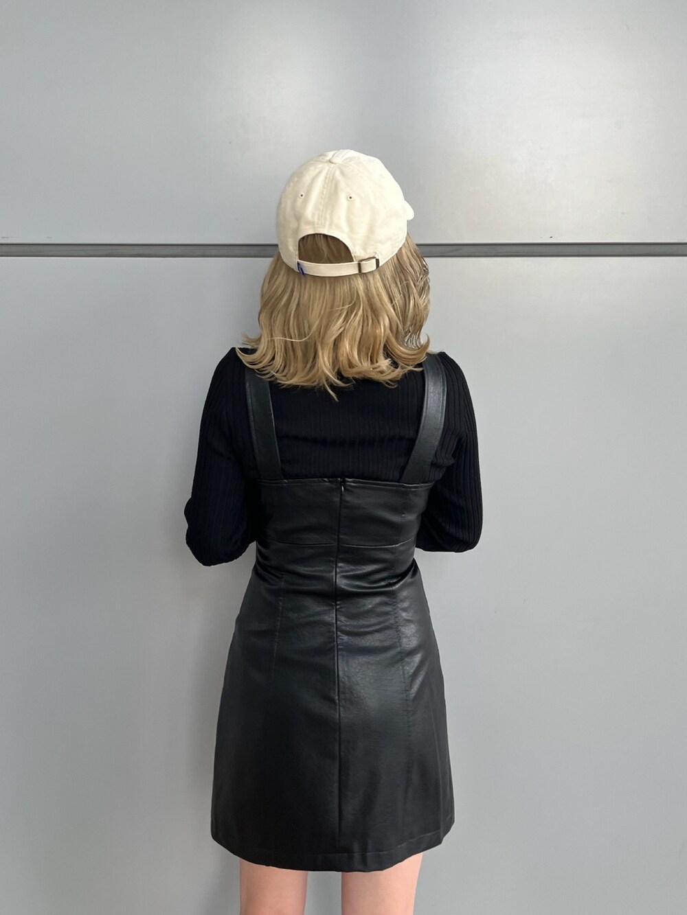 ブラック系のワンピース、ブラック系のニット/セーター、グレー系のスニーカーを着用したレディースの冬コーディネートの6枚目の写真