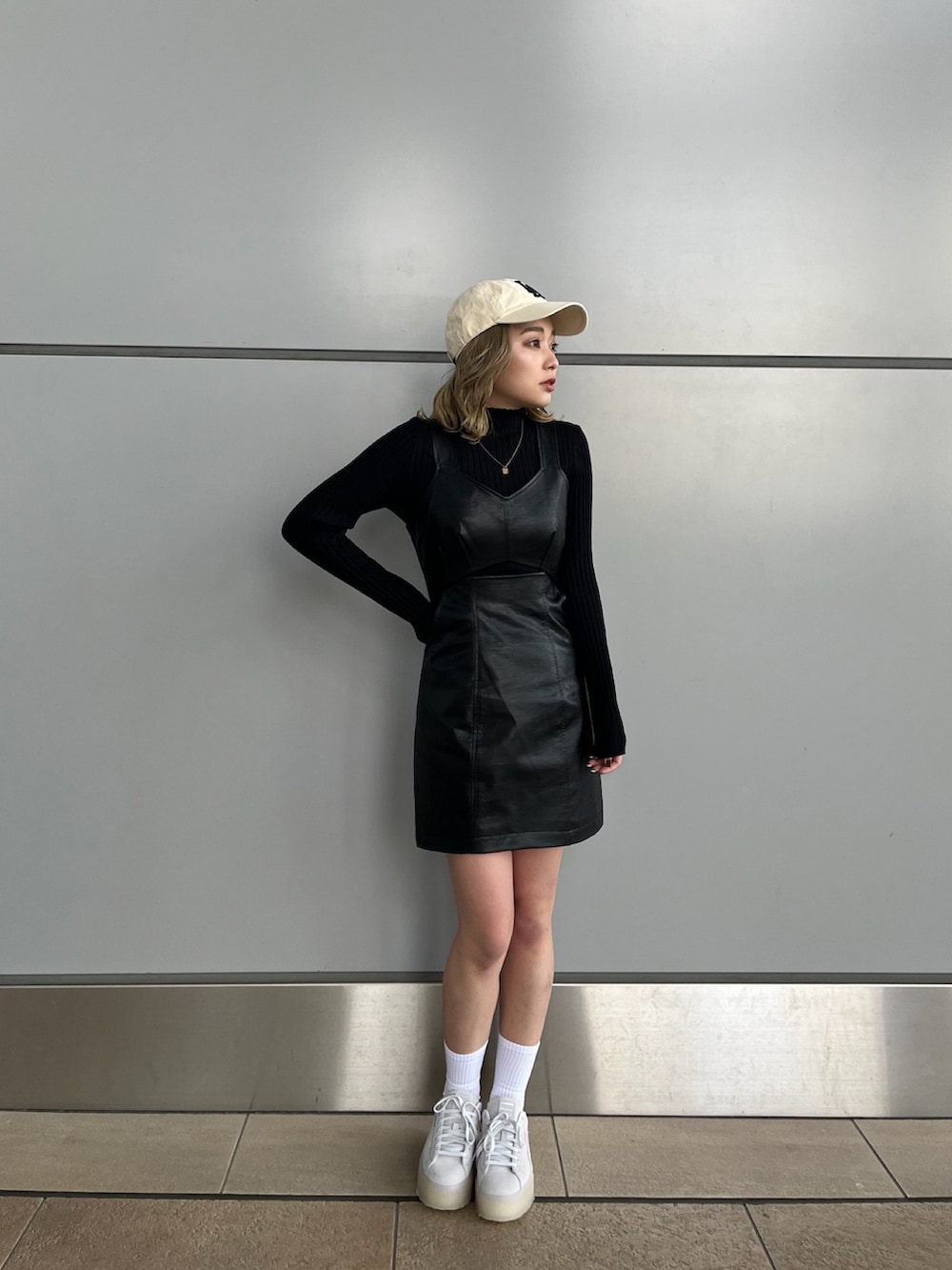 ブラック系のワンピース、ブラック系のニット/セーター、グレー系のスニーカーを着用したレディースの冬コーディネートの3枚目の写真