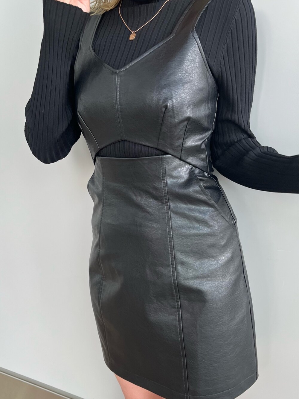 ブラック系のワンピース、ブラック系のニット/セーター、グレー系のスニーカーを着用したレディースの冬コーディネートの7枚目の写真