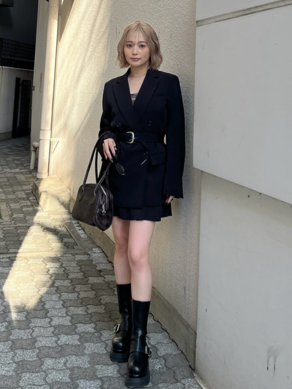 ブラック系のブーツ、ブラック系のテーラードジャケット、ブラウン系のキャミソールを着用したレディースの春コーディネートの6枚目の写真