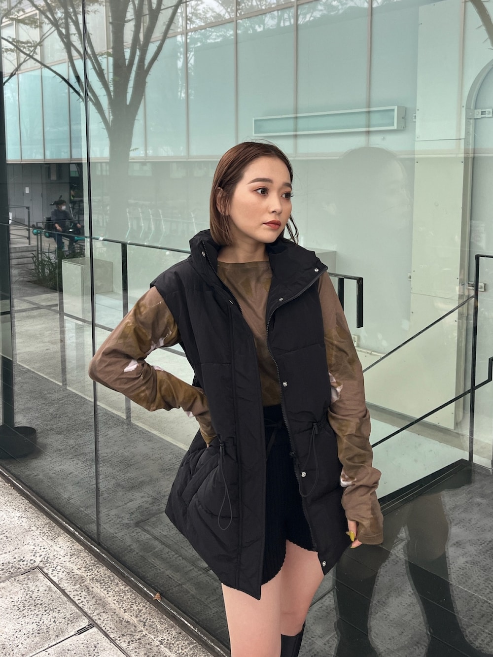 ブラック系のダウンベスト、ブラウン系のTシャツ/カットソー、ブラック系のその他パンツを着用したレディースの秋コーディネートの3枚目の写真