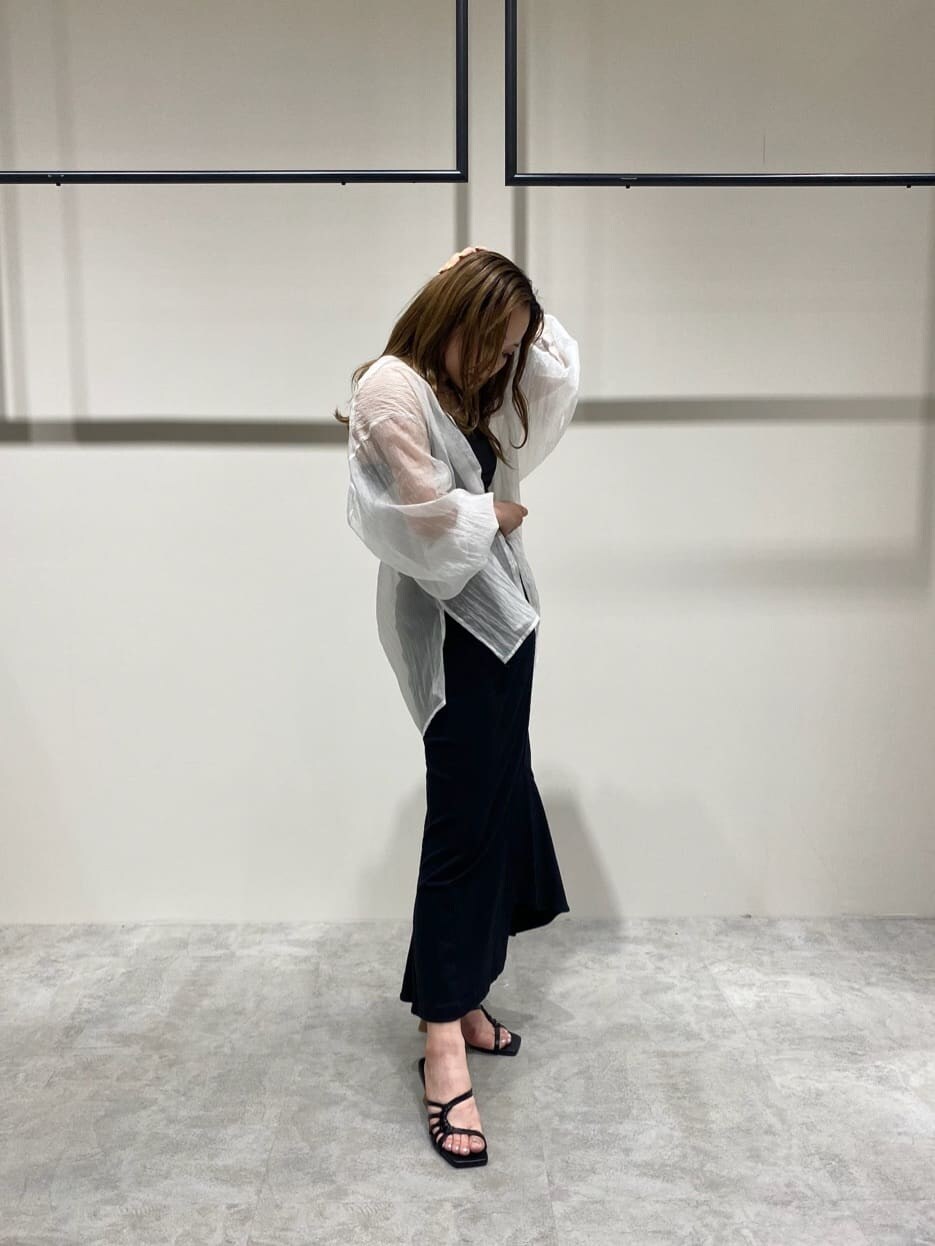 ブラック系のスカート、ホワイト系のシャツ/ブラウス、ブラック系のサンダルを着用したレディースの春コーディネートの3枚目の写真