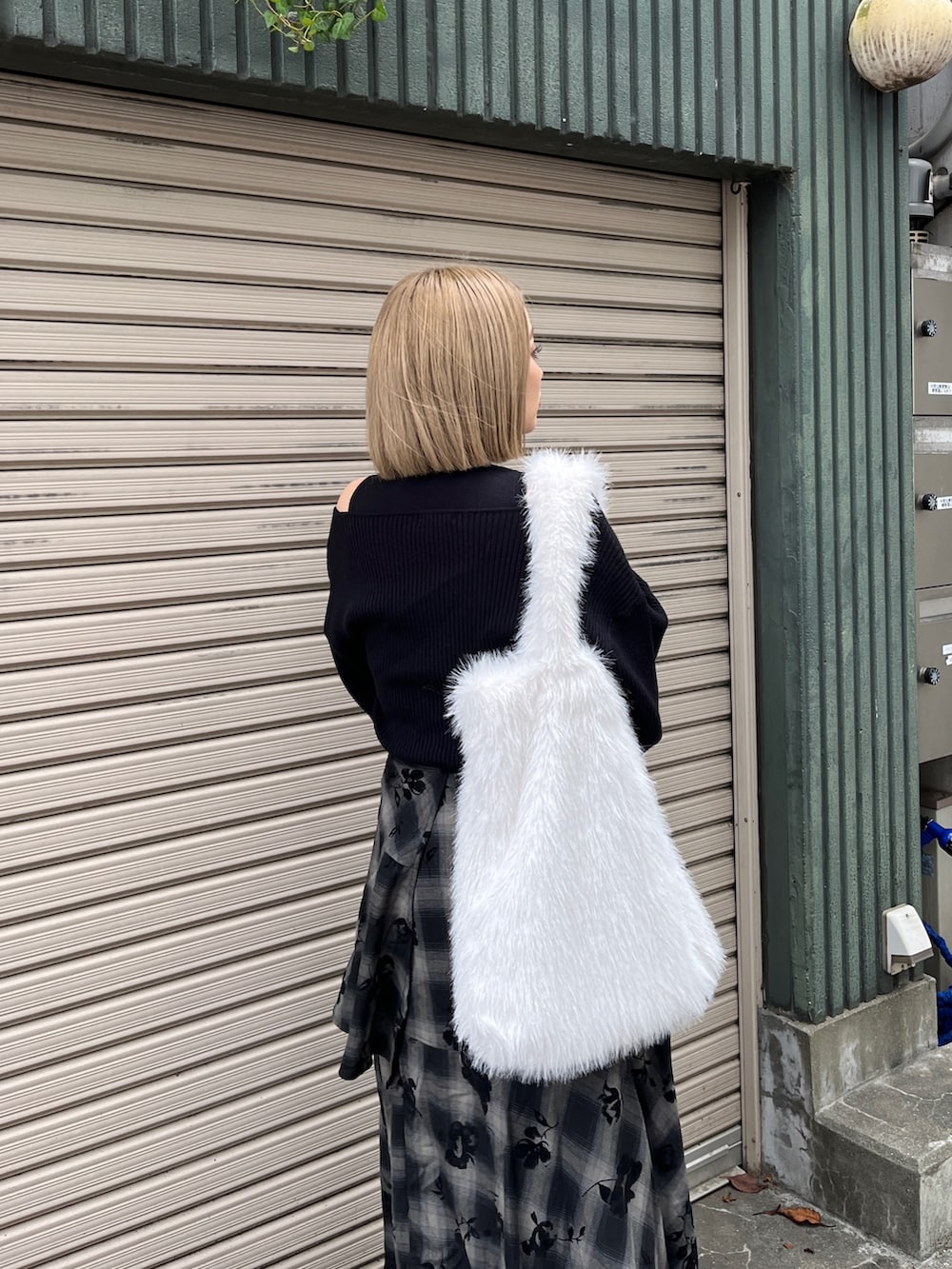 ブラック系のニット/セーター、ブラック系のスカート、ホワイト系のトートバッグを着用したレディースの冬コーディネートの6枚目の写真