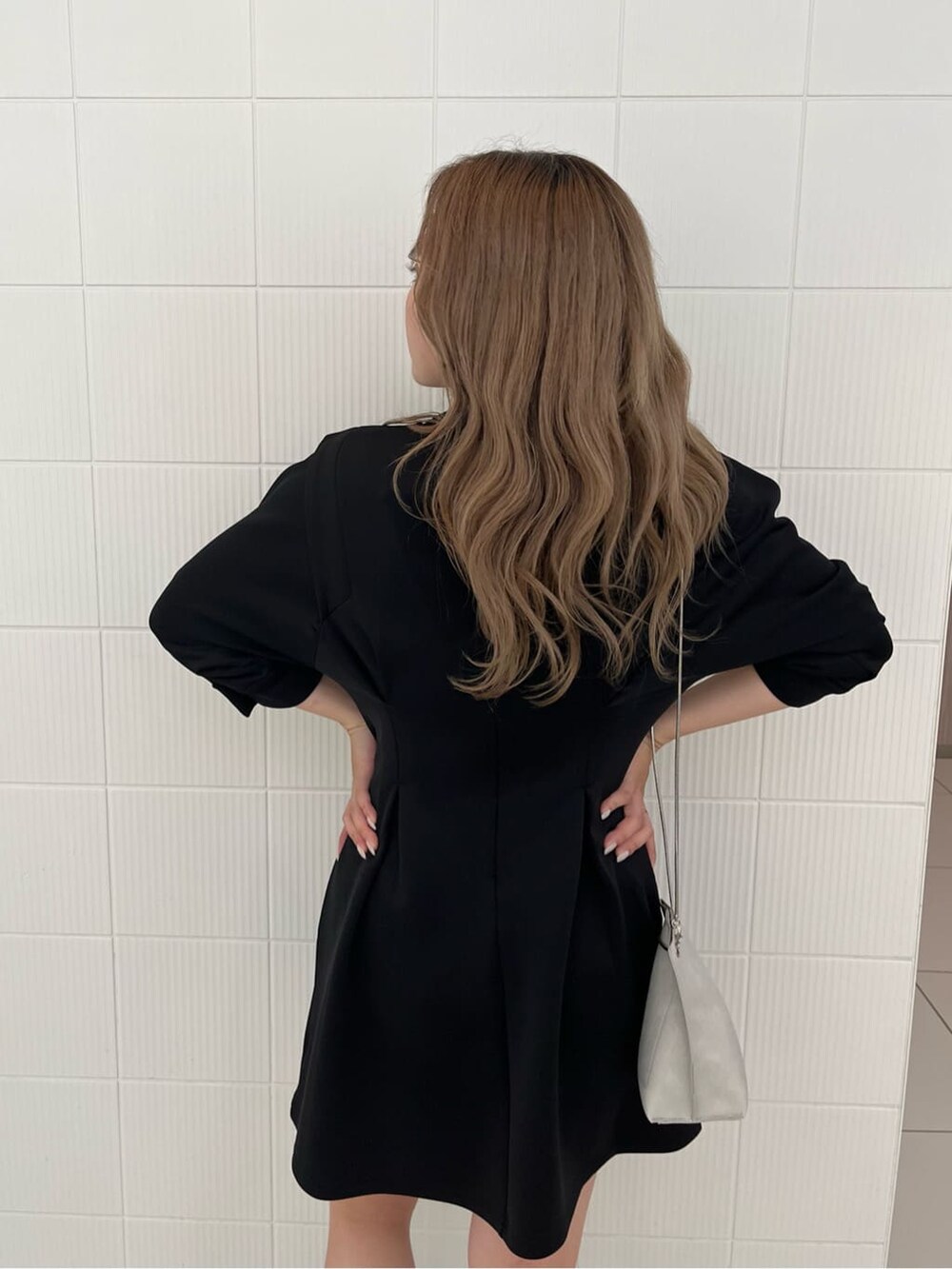 ブラック系のワンピース、ホワイト系のショルダーバッグ、ブラック系のローファーを着用したレディースの夏コーディネートの7枚目の写真