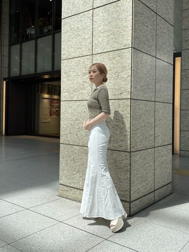 ホワイト系のキャミソール、ブラウン系のポロシャツ、ホワイト系のデニムスカートを着用したレディースの春コーディネートの2枚目の写真