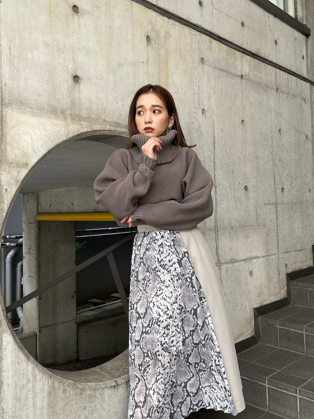 ブラウン系のニット/セーター、ホワイト系のスカート、ブラック系のブーツを着用したレディースの秋コーディネートの5枚目の写真