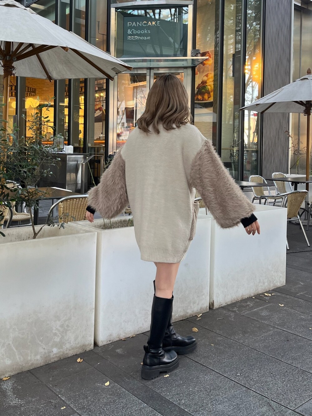 ベージュ系のカーディガン/ボレロ、ブラック系のニット/セーター、ブラック系のブーツを着用したレディースの秋コーディネートの4枚目の写真