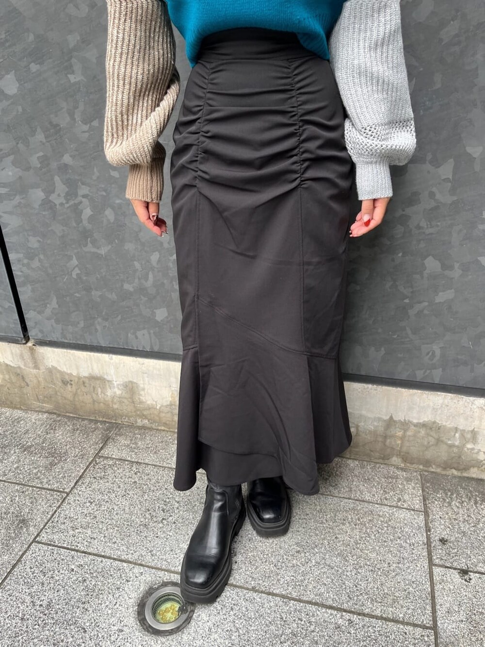 ブルー系のニット/セーター、ブラック系のスカートを着用したレディースの秋コーディネートの9枚目の写真