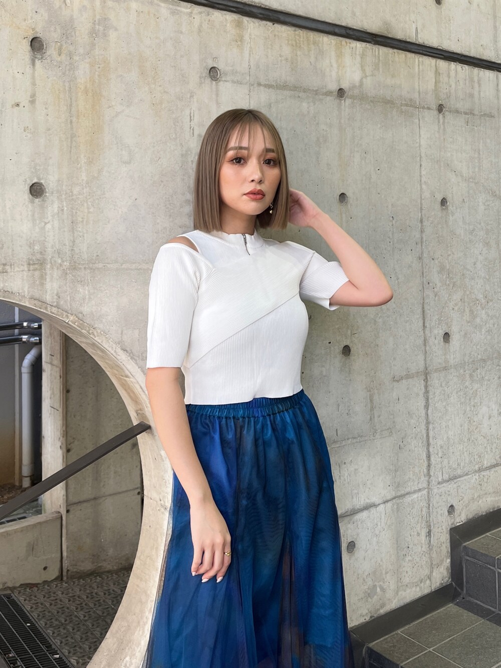 ホワイト系のニット/セーター、ブルー系のスカート、ホワイト系のサンダルを着用したレディースの冬コーディネートの5枚目の写真