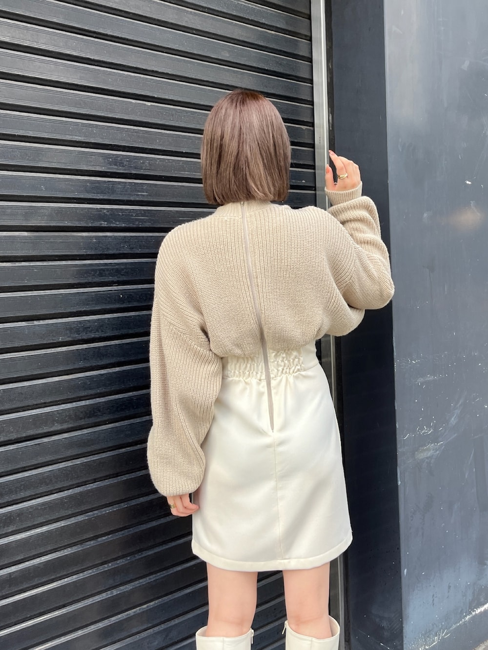 ベージュ系のワンピース、ホワイト系のブーツを着用したレディースの秋コーディネートの5枚目の写真