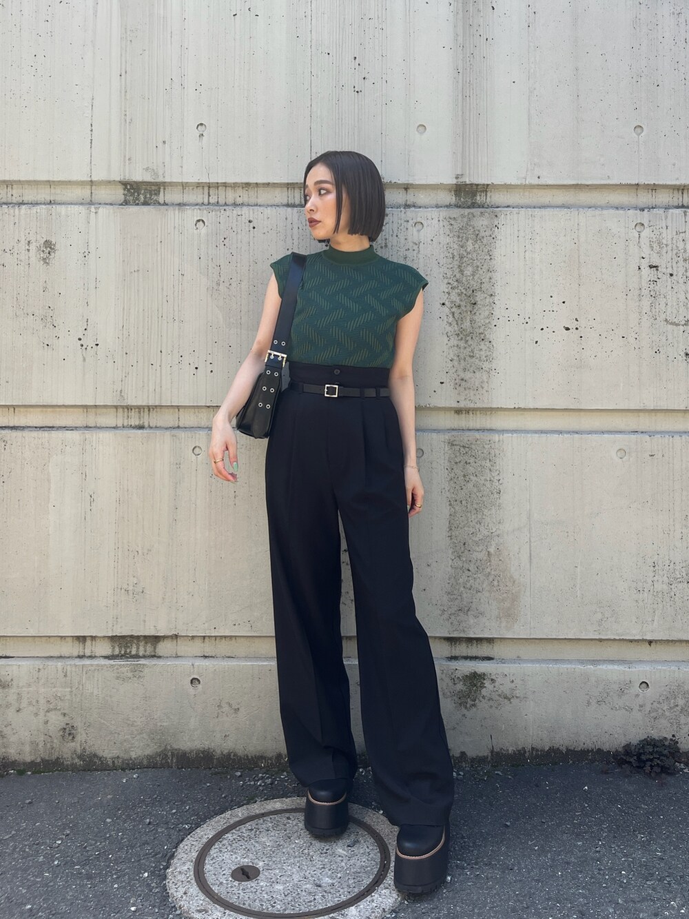 グリーン系のニット/セーター、ブラック系のその他パンツ、ブラック系のブーツを着用したレディースの夏コーディネートの4枚目の写真