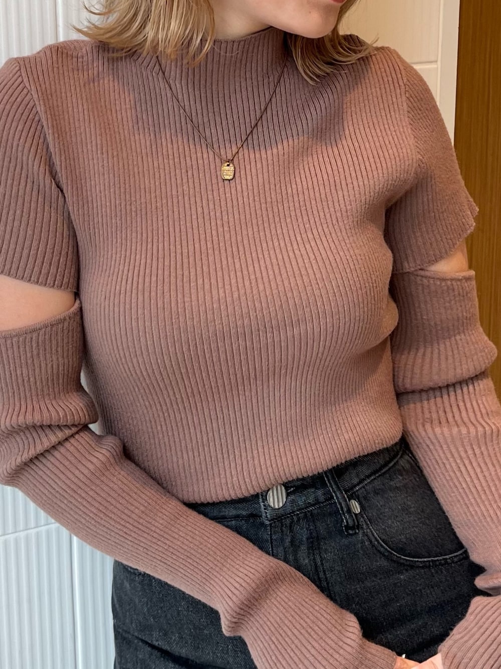 ブラック系のデニムパンツ、ブラウン系のニット/セーター、ブラック系のブーツを着用したレディースの冬コーディネートの7枚目の写真